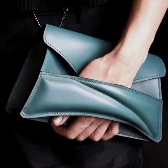 Lindasieto Link Bag, sculptural jade green leather clutch with a chain strap, close up detail of wrist strap and soft, green nappa leather texture. Magyar kortárs designer jade zöld bőr alkalmi női clutch táska, puha bőr csuklóőánt design és varrás részlete