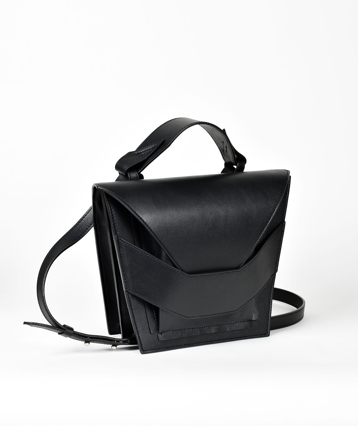 Avantgarde edgy bag handcrafted from genuine Italian leather, custom colors, black handbag, crossbody purse with unique wrist strap by Hungarian, Budapest based designer. Fekete, választható színű bőr designer válltáska magyar táska tervező márka.