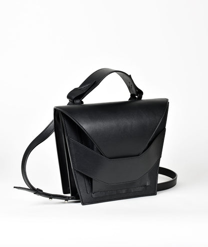 Avantgarde edgy bag handcrafted from genuine Italian leather, custom colors, black handbag, crossbody purse with unique wrist strap by Hungarian, Budapest based designer. Fekete, választható színű bőr designer válltáska magyar táska tervező márka.