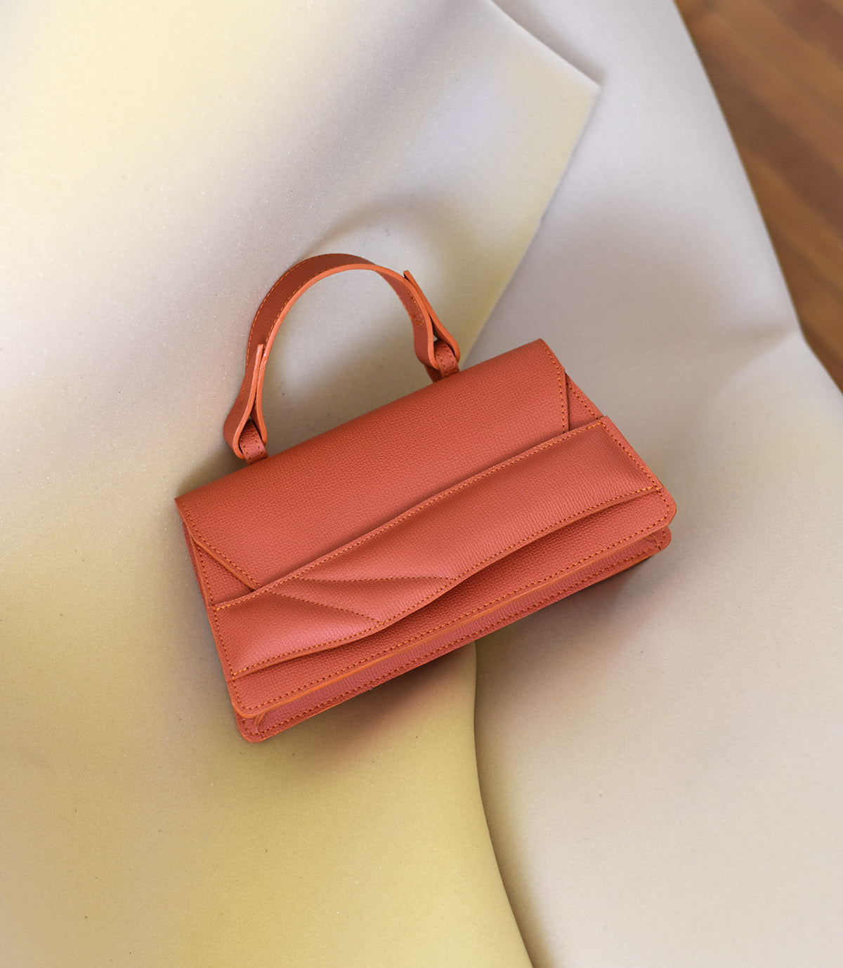 Magyar designer bőr crossbody táska, egyedi, női, uniszex, iparművész válltáska, különleges színekben, személyre szabott monogram, ajándék csomagolással. Handmade genuine leather orange crossbody bag by Budapest based fashion designer, unique wrist strap handle, gift wrap available. Limited quantities, ethical production.