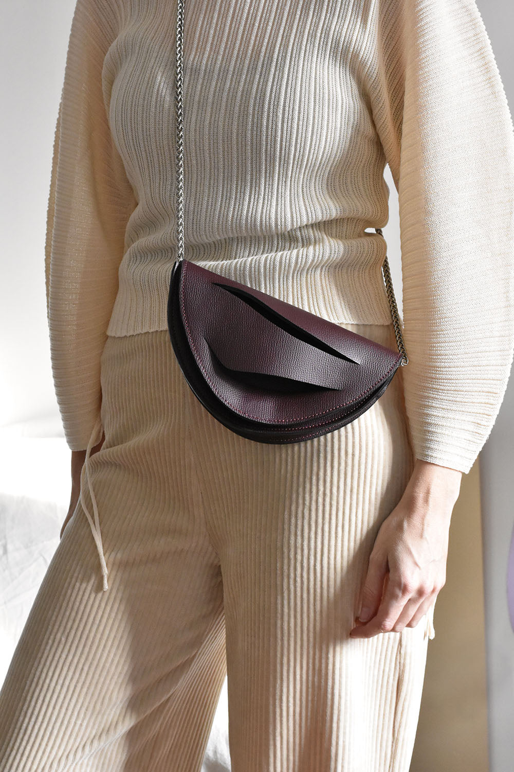 Handmade clutch bag handcrafted from genuine Italian leather, custom colors, black red burgundy garnet wine handbag, crossbody purse with unique wrist strap by Hungarian, Budapest based designer. Fekete, bordó választható színű bőr designer borítéktáska, táska, válltáska magyar táskatervező márka.