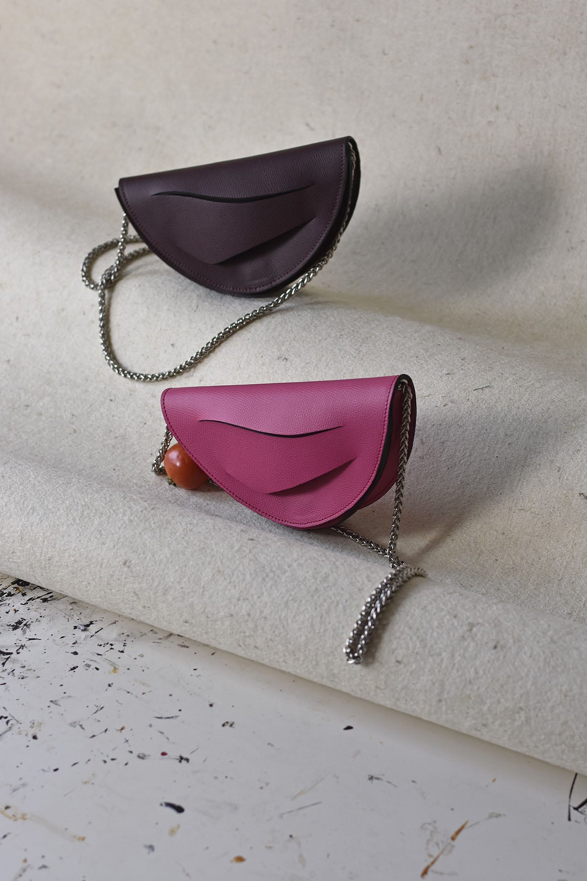 Handmade clutch bag handcrafted from genuine Italian leather, custom colors, black red burgundy garnet wine handbag, crossbody purse with unique wrist strap by Hungarian, Budapest based designer. Fekete, bordó választható színű bőr designer borítéktáska, táska, válltáska magyar táskatervező márka.