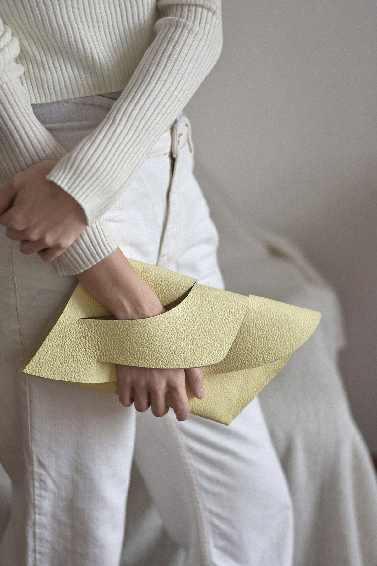 Handmade clutch bag handcrafted from genuine Italian leather, custom colors, light lemon yellow cream handbag, purse with unique wrist strap by Hungarian, Budapest based designer. Világos sárga, választható színű bőr designer borítéktáska, táska, magyar táskatervező márka.
