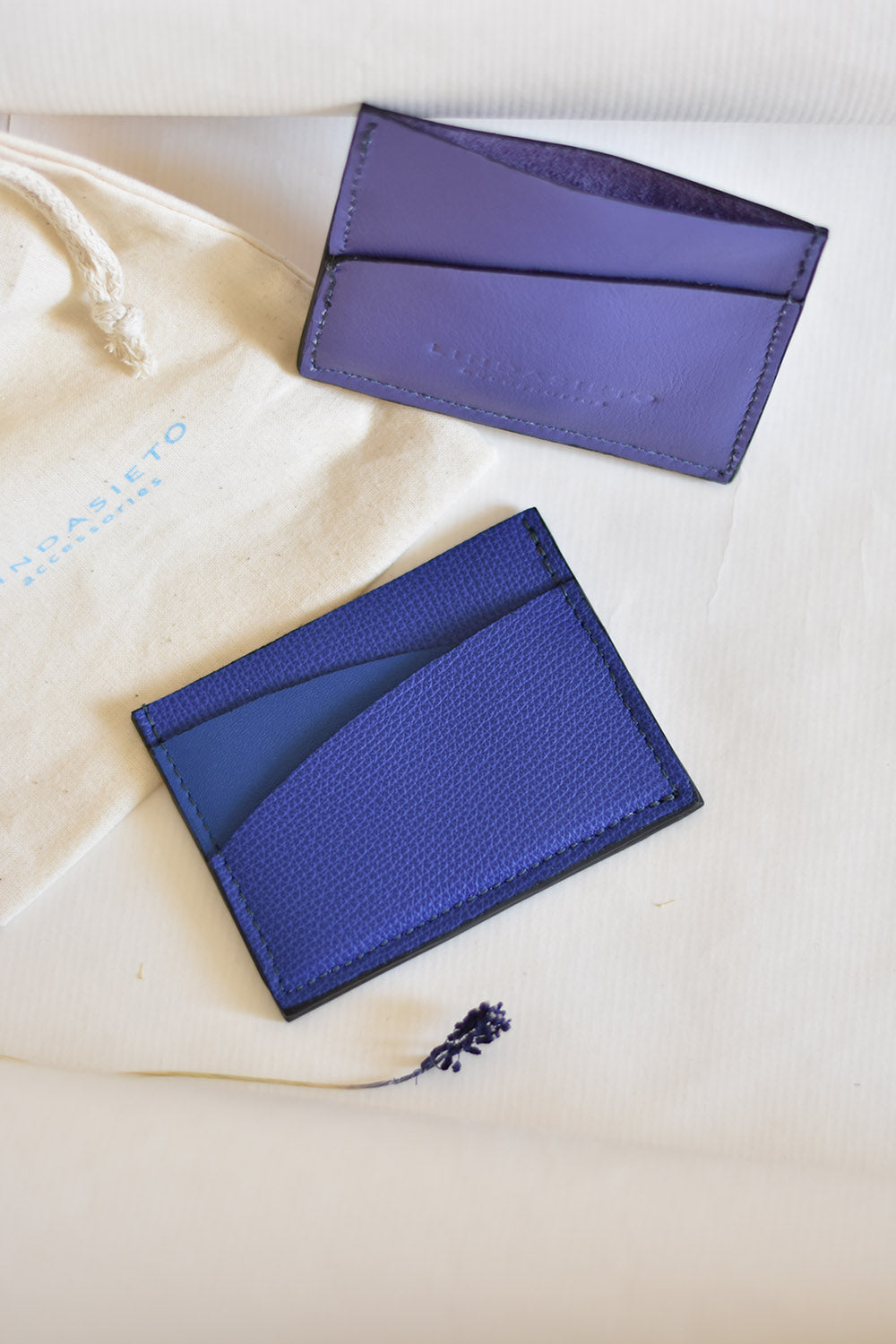 Ultramarine blue and purple leather cardholder wallets, on cotton gift bag with logo print. Színes, kék és lila bőr kártyatartók, ajándék csomagolással, textil zsákkal magyar tervezőtől.