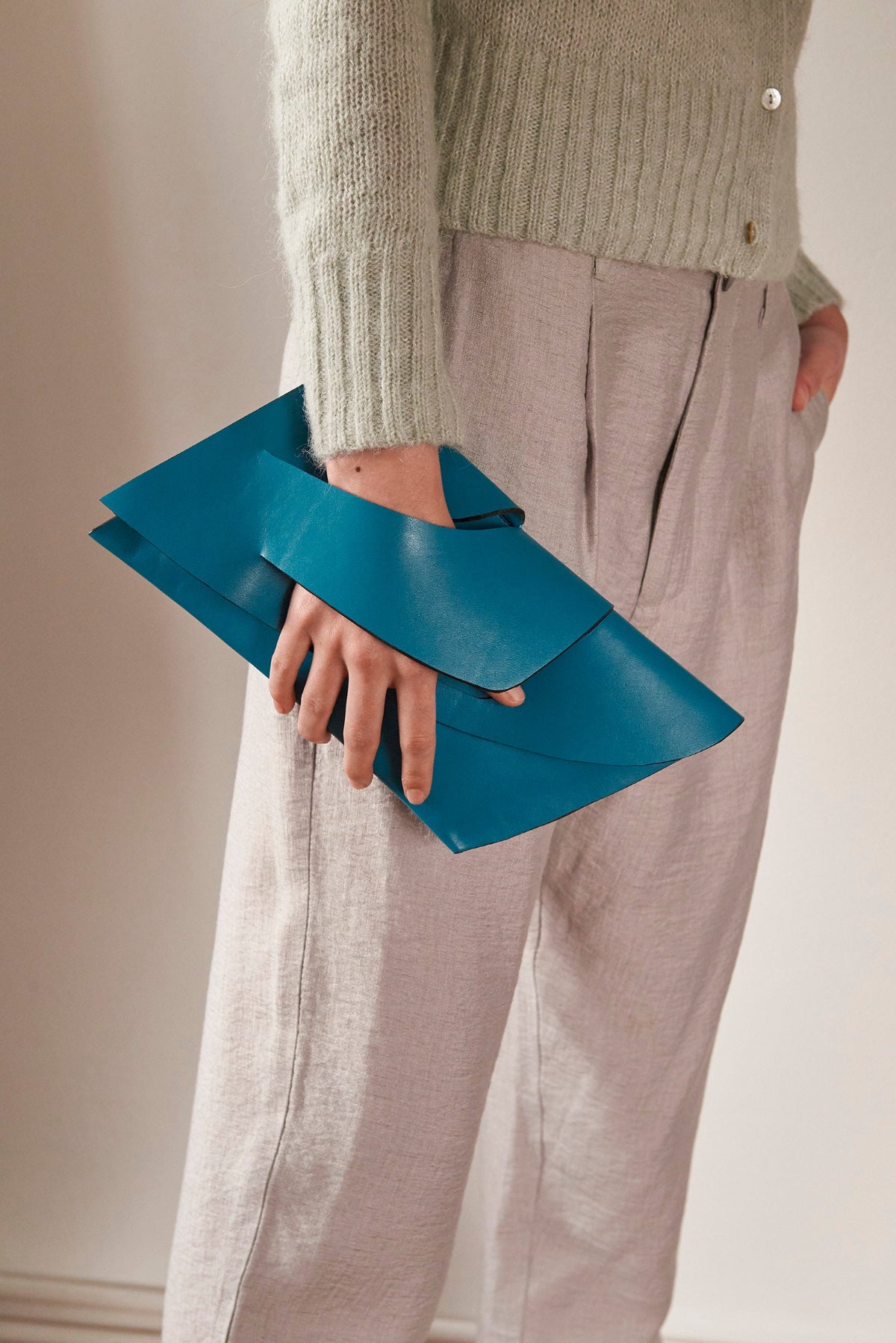 Handmade teal green blue genuine leather handbag, clutch purse with unique wrist strap by Hungarian, Budapest based designer. Bőr designer borítéktáska, magyar táskatervező márka.