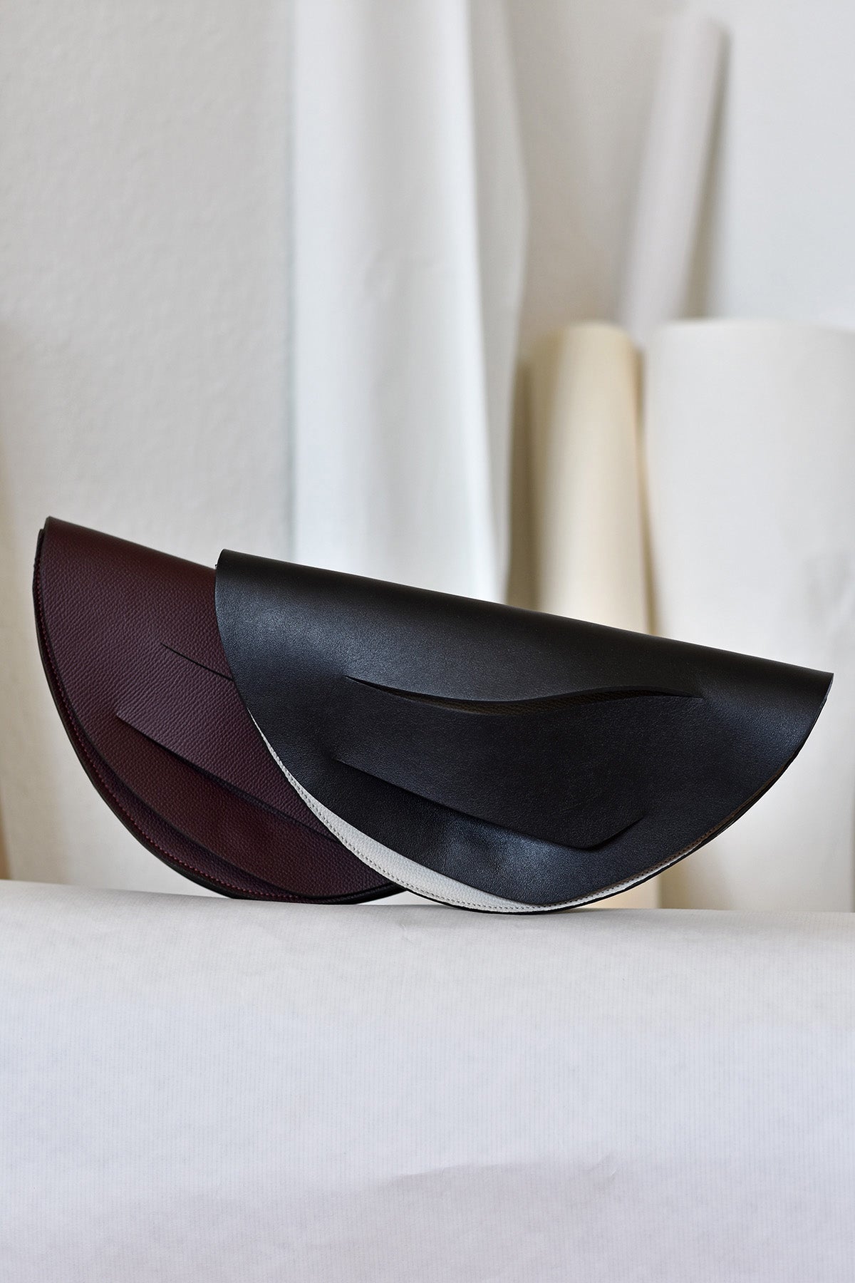 Lindasieto Dune, fekete bőr magyar designer táska, válltáska, tervezői márka. Sculptural, minimalist clutch bag, genuine Italian leather, custom colors, black handbag, luxury crossbody purse with unique wrist strap by Hungarian, Budapest based independent designer. 