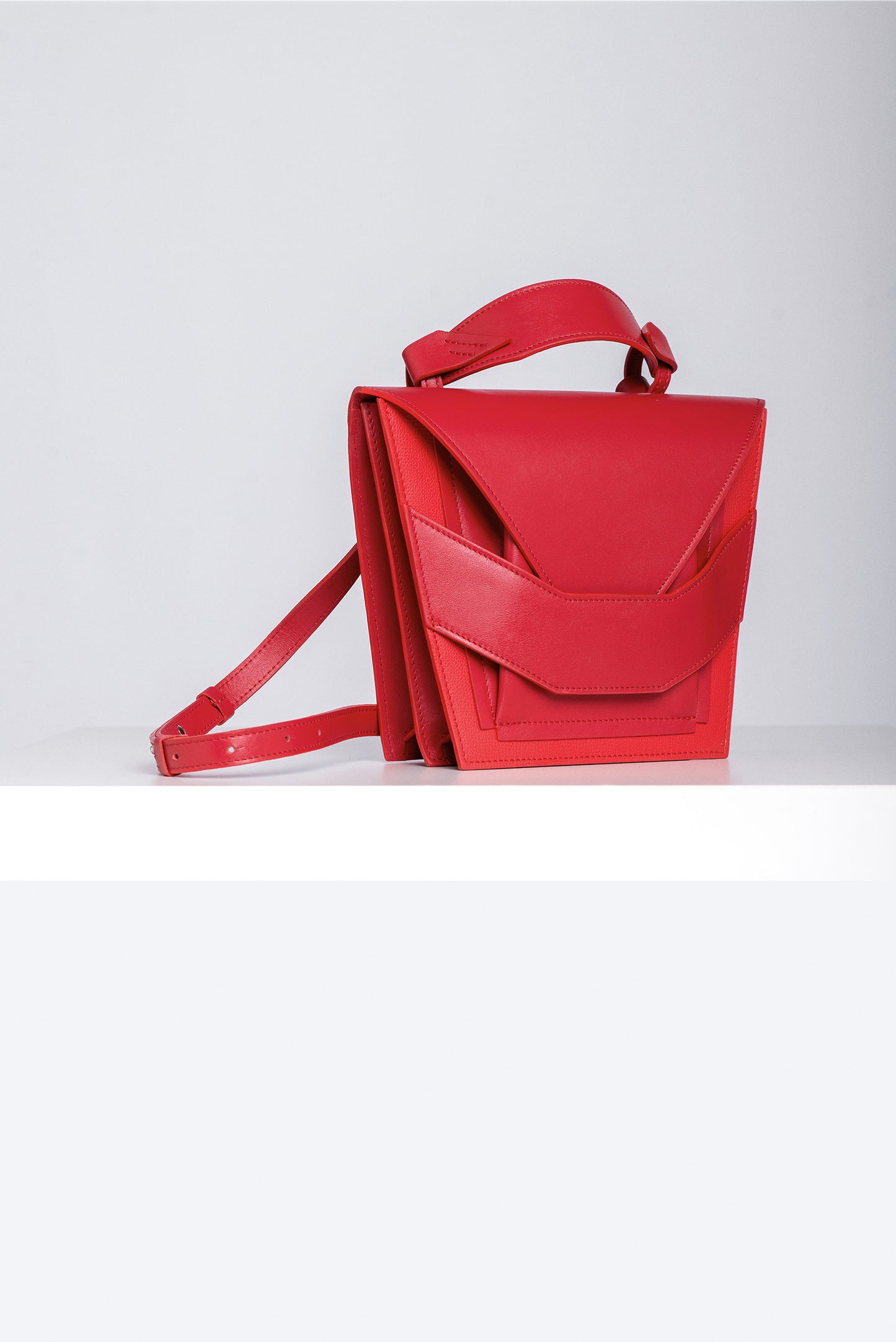 Lindasieto Layered Bag handcrafted from luxurious Italian red nappa leather, sculptural minimalist handbag, crossbody purse with unique wrist strap by Hungarian, Budapest based designer. Piros bőr kortárs designer válltáska magyar táska tervező márka.