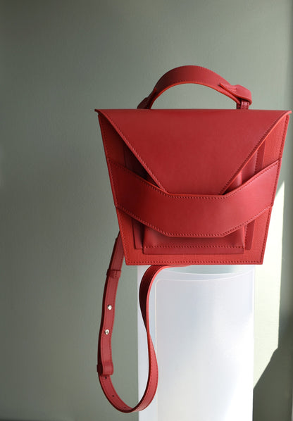 Lindasieto Layered Bag handcrafted from luxurious Italian red nappa leather, sculptural minimalist handbag, crossbody purse with unique wrist strap by Hungarian, Budapest based designer. Piros bőr kortárs designer válltáska magyar táska tervező márka.
