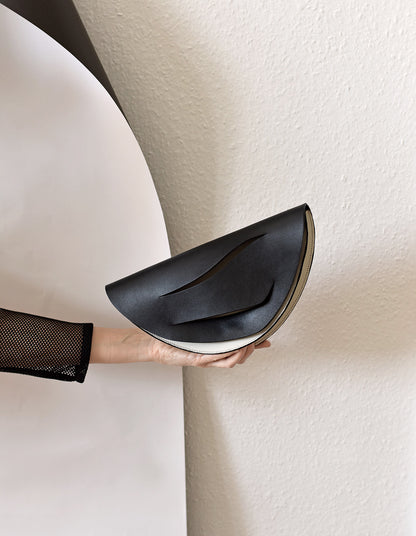 Lindasieto Dune, fekete bőr magyar designer táska, válltáska, tervezői márka. Sculptural, minimalist clutch bag, genuine Italian leather, custom colors, black handbag, luxury crossbody purse with unique wrist strap by Hungarian, Budapest based independent designer. 