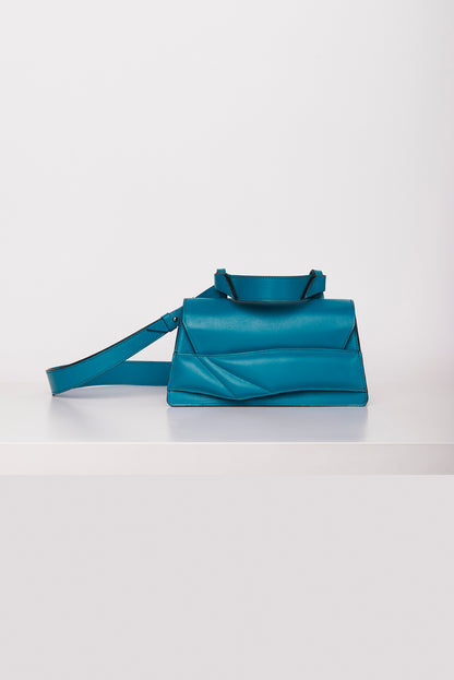 Lindasieto magyar designer türkiz kék bőr crossbody táska, egyedi, női, uniszex, iparművész válltáska, különleges színekben, személyre szabott monogram, ajándék csomagolással. Handmade genuine teal nappa leather crossbody bag by Budapest based fashion designer, unique wrist strap handle, gift wrap available. Limited quantities, ethical production.
