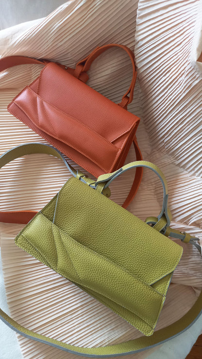 Magyar designer bőr crossbody táska, egyedi, női, uniszex, iparművész válltáska, különleges színekben, személyre szabott monogram, ajándék csomagolással. Handmade genuine leather orange crossbody bag by Budapest based fashion designer, unique wrist strap handle, gift wrap available. Limited quantities, ethical production.
