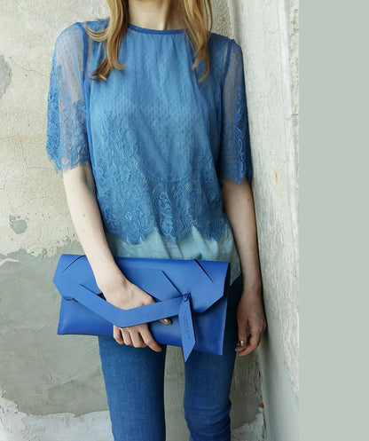 Blue contemporary genuine leather clutch bag, purse with unique wrist strap, worn in hand. Egyedi bőr boríték táska, csukló pánttal, kék színben, magyar márka terméke.